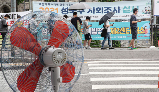 13일 오전 서울 성북구 돈암동 성북천 변에 마련된 바람마당 임시선별검사소에 코로나19 검사를 받으려는 시민들이 불볕더위 속에 대기하고 있다. 연합뉴스